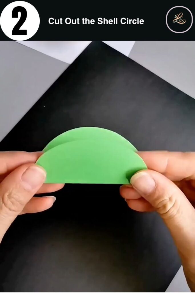 Scissors cutting a circle from orange cardstock to make a paper snail shell