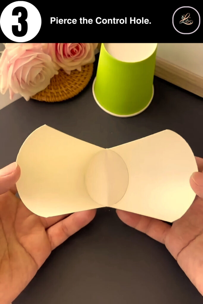 Piercing a hole in the bottom of a paper cup with a skewer.