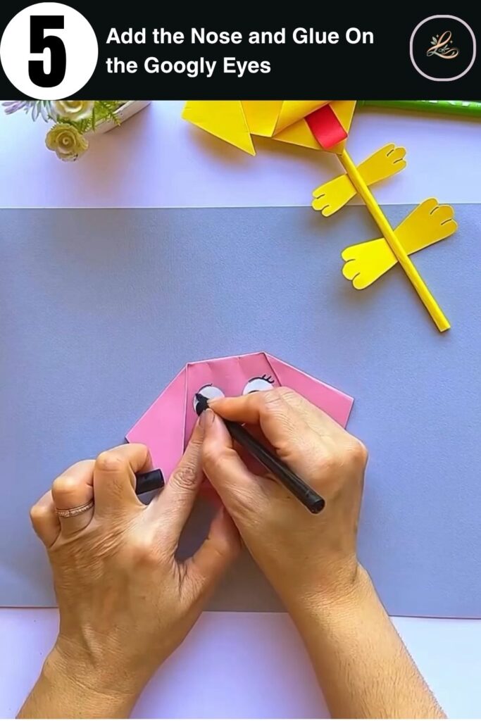 Gluing googly eyes and brown paper nose onto a paper dog face pencil topper craft for beginners