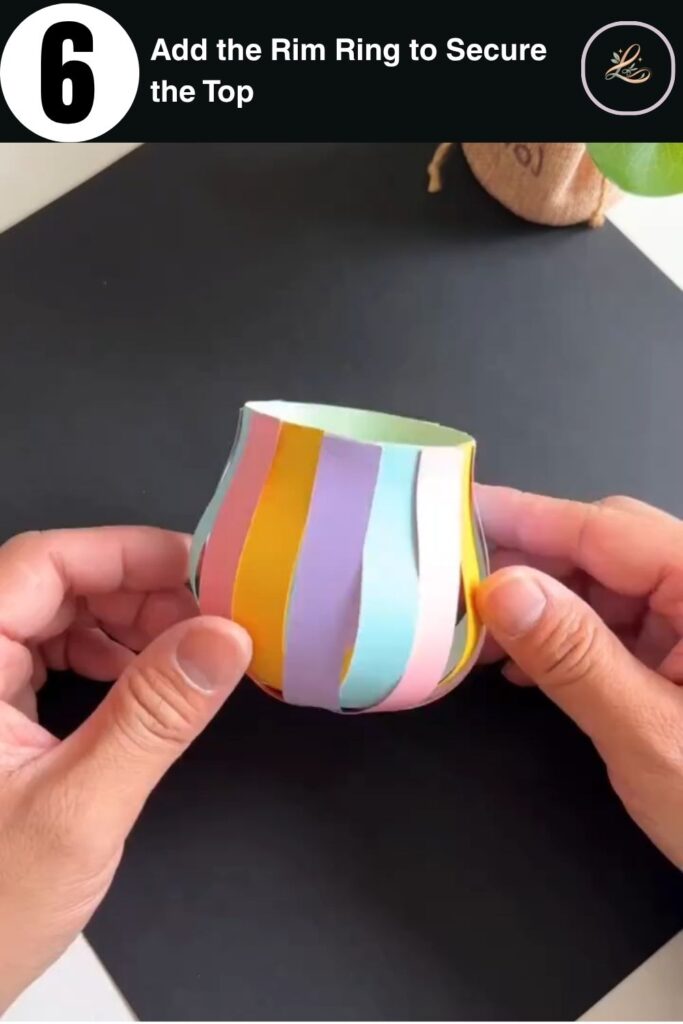 Green paper rim ring being added to the top of a colorful paper strip basket in a kids craft project