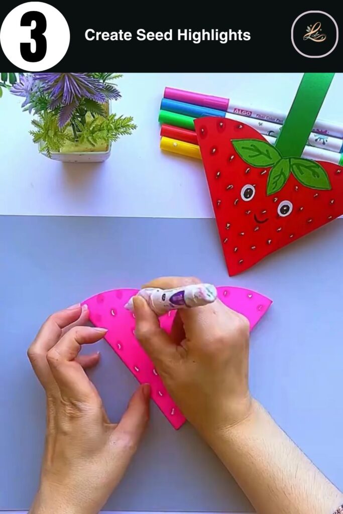Adding white highlights to paper strawberry seeds for a 3D effect.