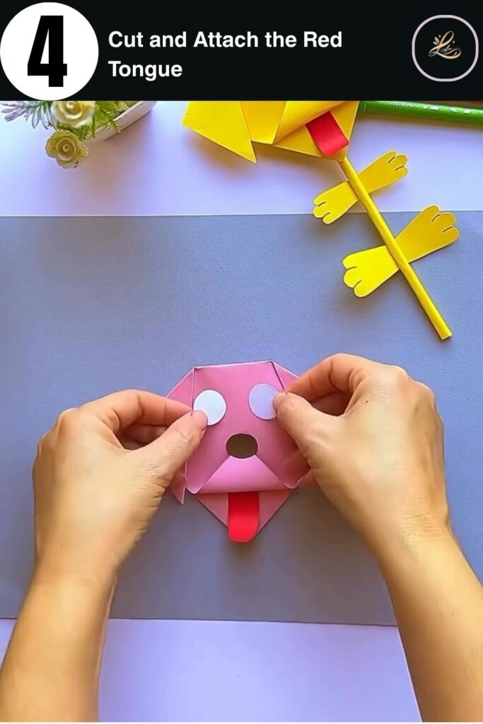 Adding a red paper tongue to a folded pink paper dog face craft pencil topper