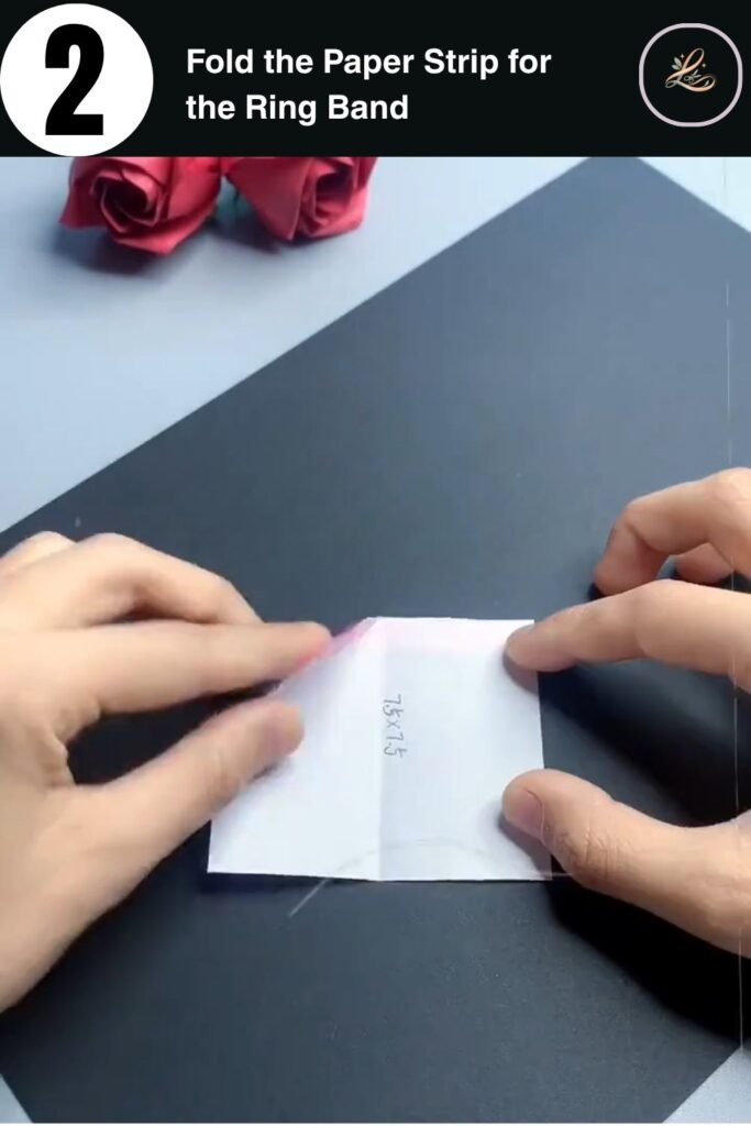 Hands folding pink paper into a rectangular strip for a paper bunny finger ring