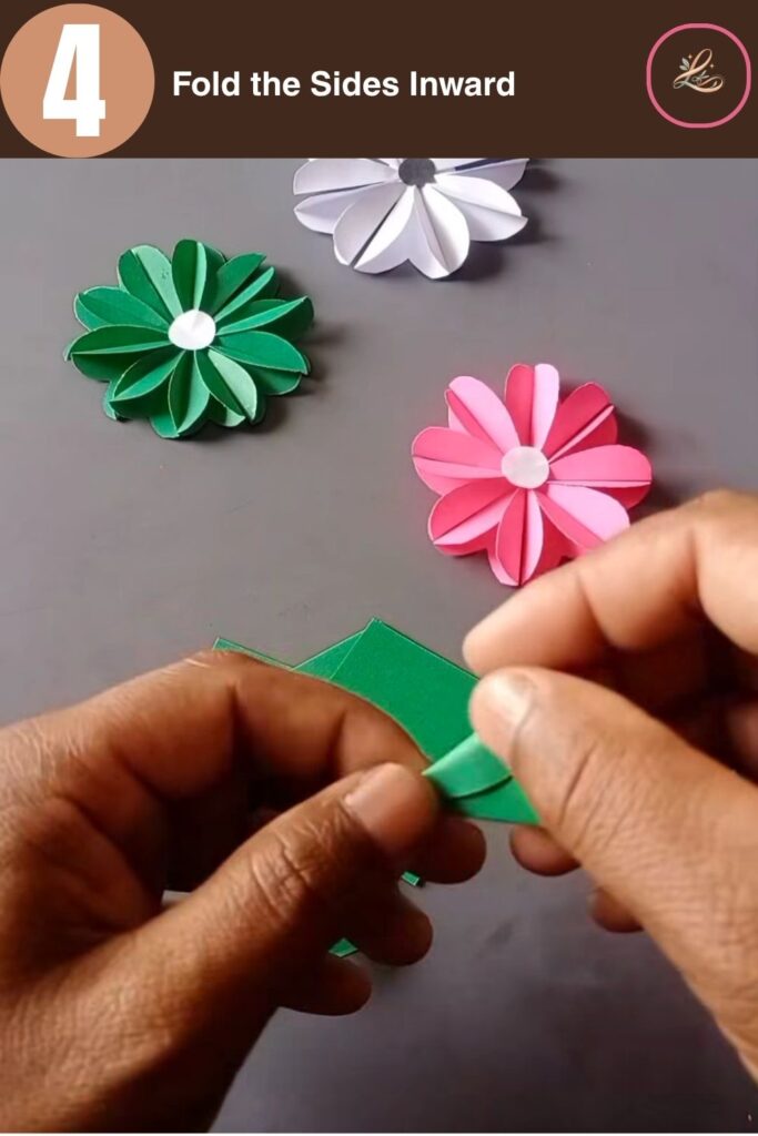 Pretty Paper Daisy Flower Craft for Kids Folding the outer edges of a paper heart shape inward to create a pointed petal look.