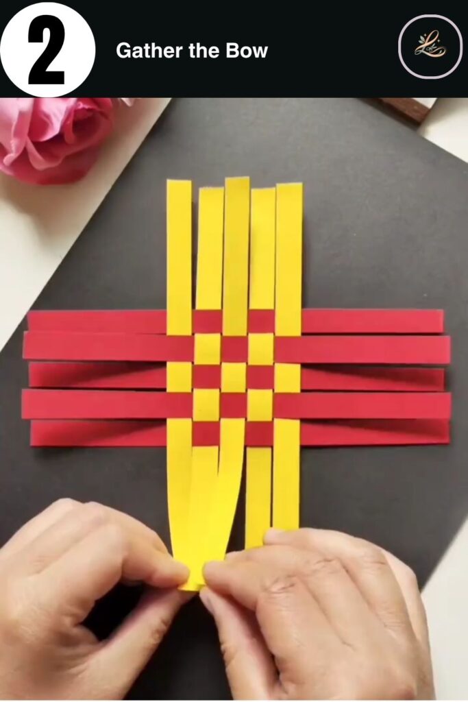 Gathering yellow paper strips to form the front of a paper boat.
