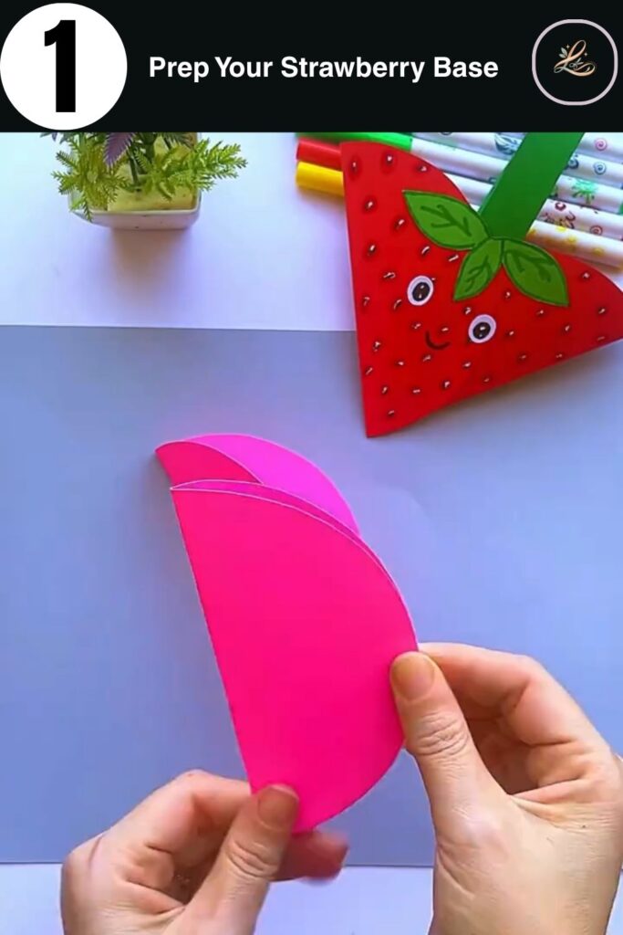 Two pink paper circles folded and glued together to start a strawberry craft.