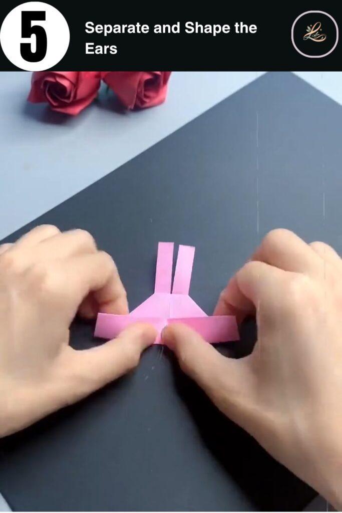 Pink paper bunny ring shape with two ears standing upright before drawing the face