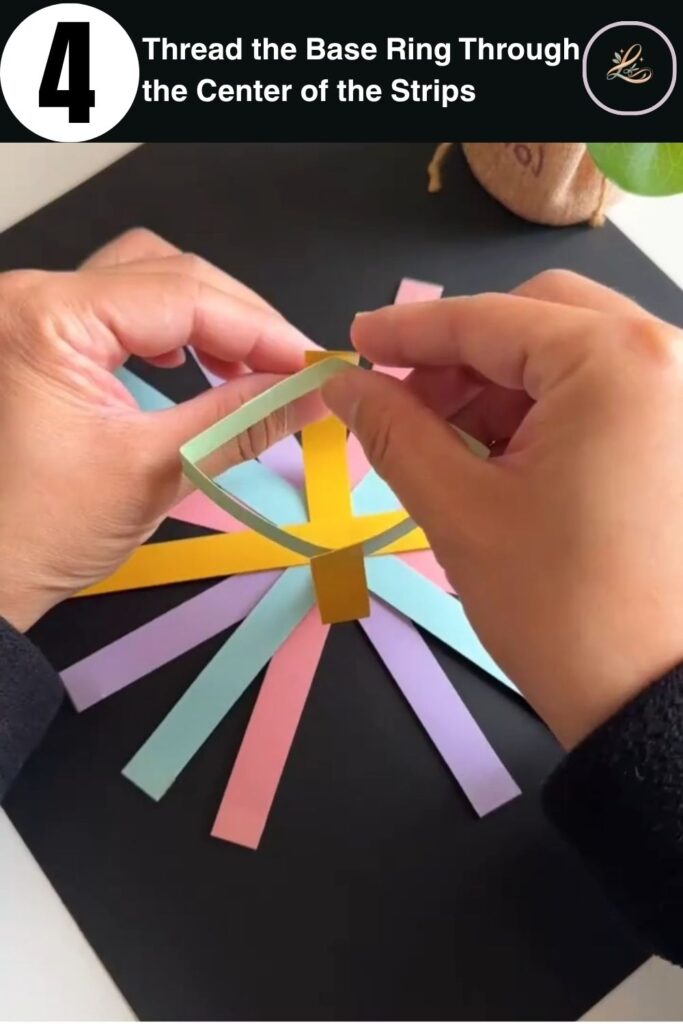 Green paper ring being placed over the center of colorful paper strips during a kids paper basket craft tutorial