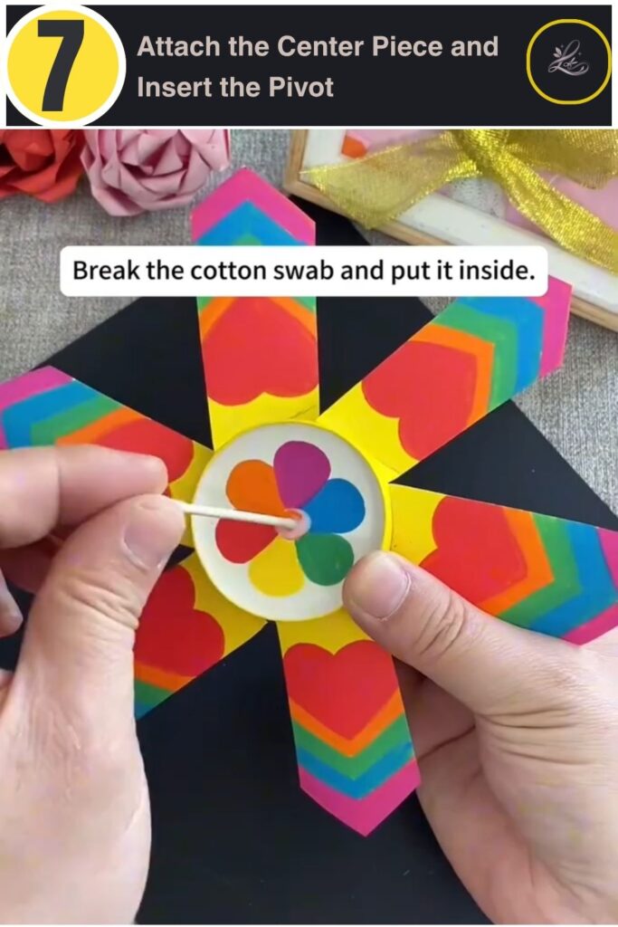 Inserting a broken cotton swab as a pivot in a paper pinwheel center