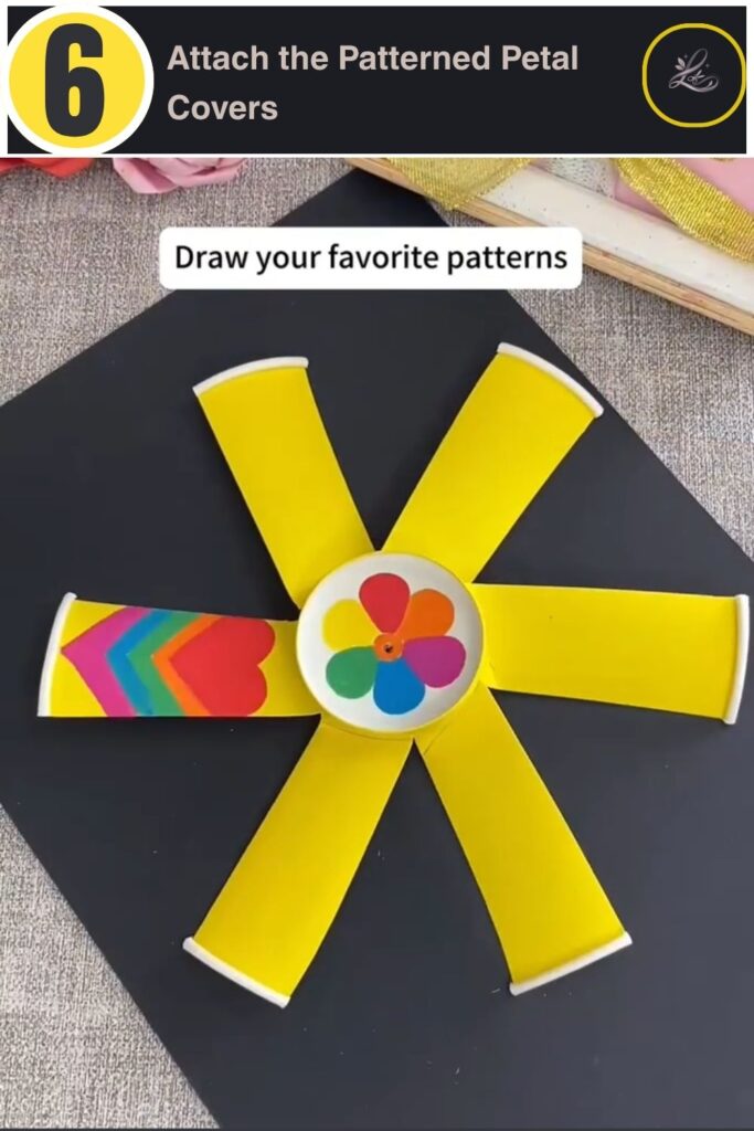 Gluing rainbow chevron heart patterned paper onto pinwheel petals