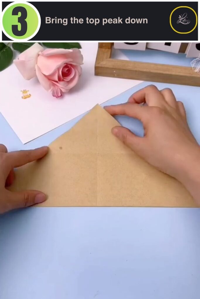 Folding the top point of the paper down over the horizontal layer.
