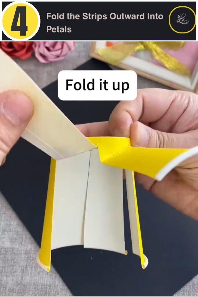 Folding paper cup strips outward to form pinwheel petals
