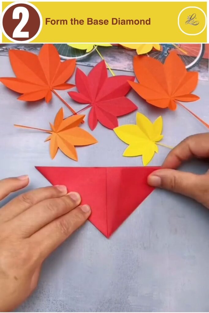 Side edges of red paper folded inward to meet a central diagonal crease line.