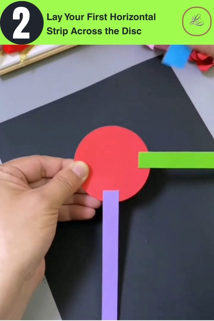 Fun Rainbow Woven Paper Pencil Holder DIY (#1) Red paper disc with a purple vertical strip and green horizontal strip crossing at the center early stage of building a DIY woven paper pencil holder