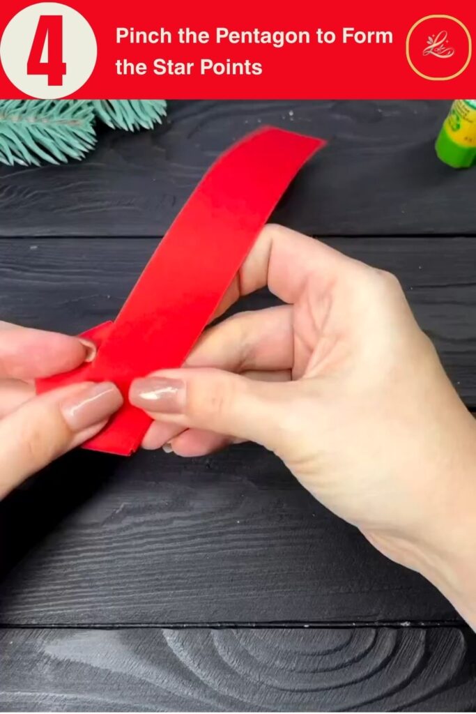 Hands pinching the sides of a paper pentagon to pop out the star points, DIY paper star Christmas ornament tutorial