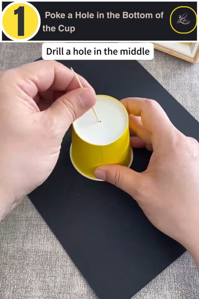 Child poking a center hole in a yellow paper cup base for a pinwheel craft