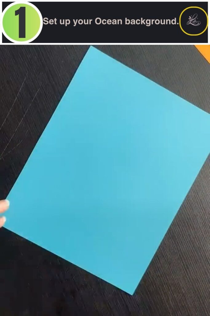 Blue cardstock background being set up for a paper fish tank craft