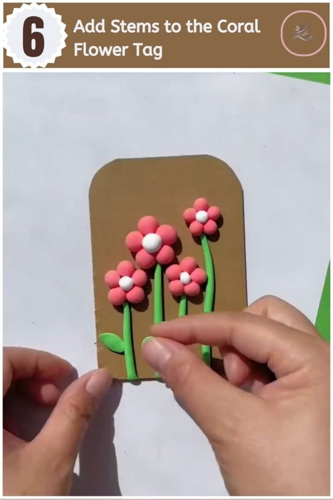 Beautiful Air Dry Clay Flower Wall Decor for Beginners Coral clay daisies with green stems arranged on a handmade wall decor tag