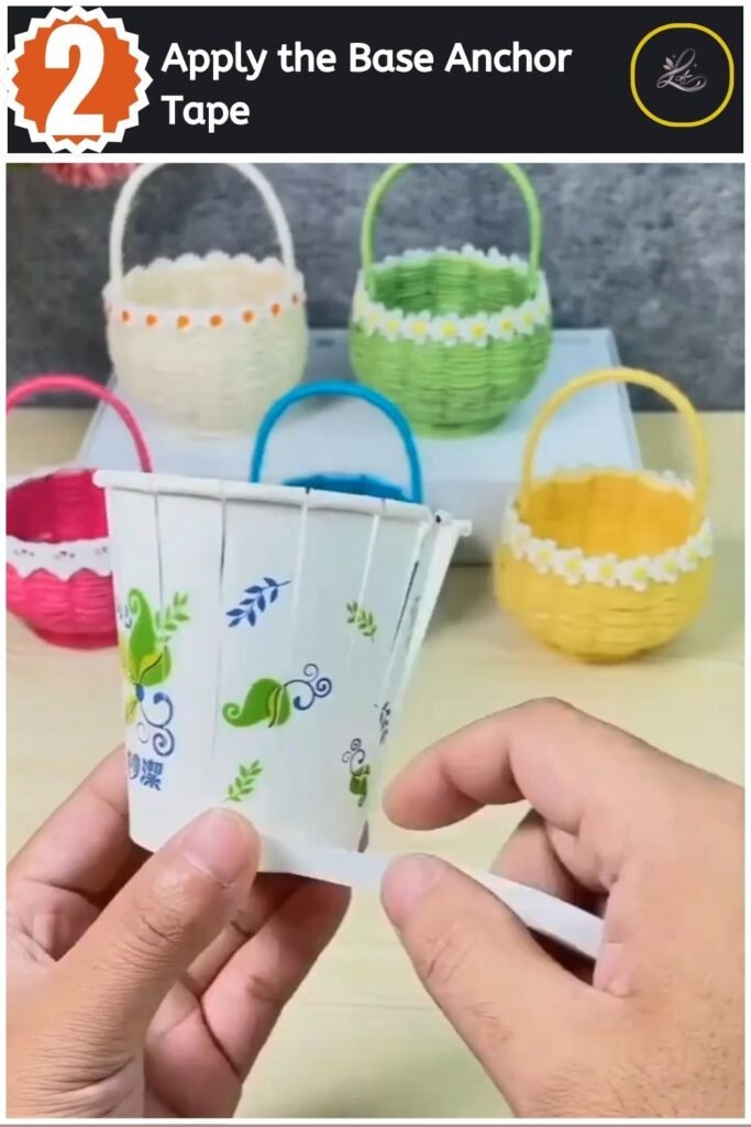 Applying double-sided white tape to the base of a cut paper cup.