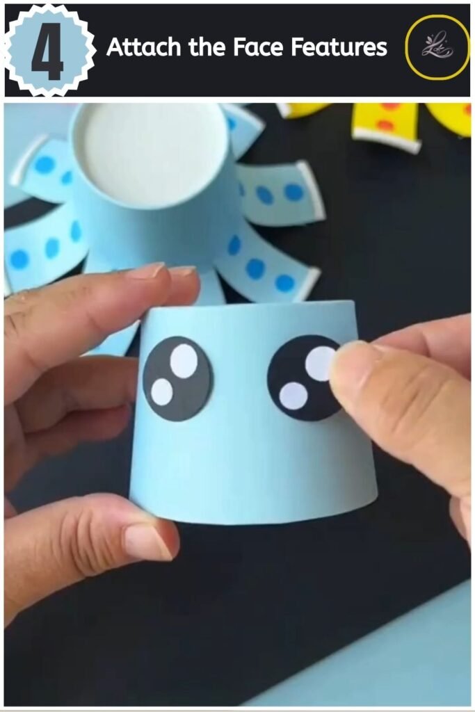Playful Paper Cup Octopus Craft for Beginners Sticking paper eye and mouth cut-outs onto the front of a paper cup craft.