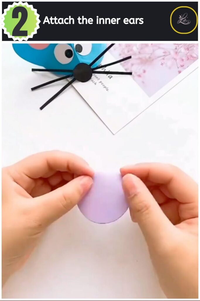 Adorable Paper Mouse Craft For Beginners Attaching a small pink paper circle to the ear of the purple paper mouse.