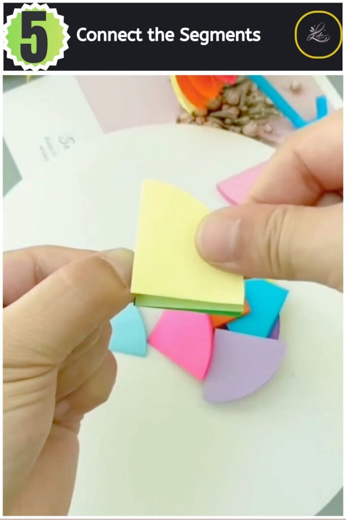 Stacking and taping multiple coloured paper segments together.