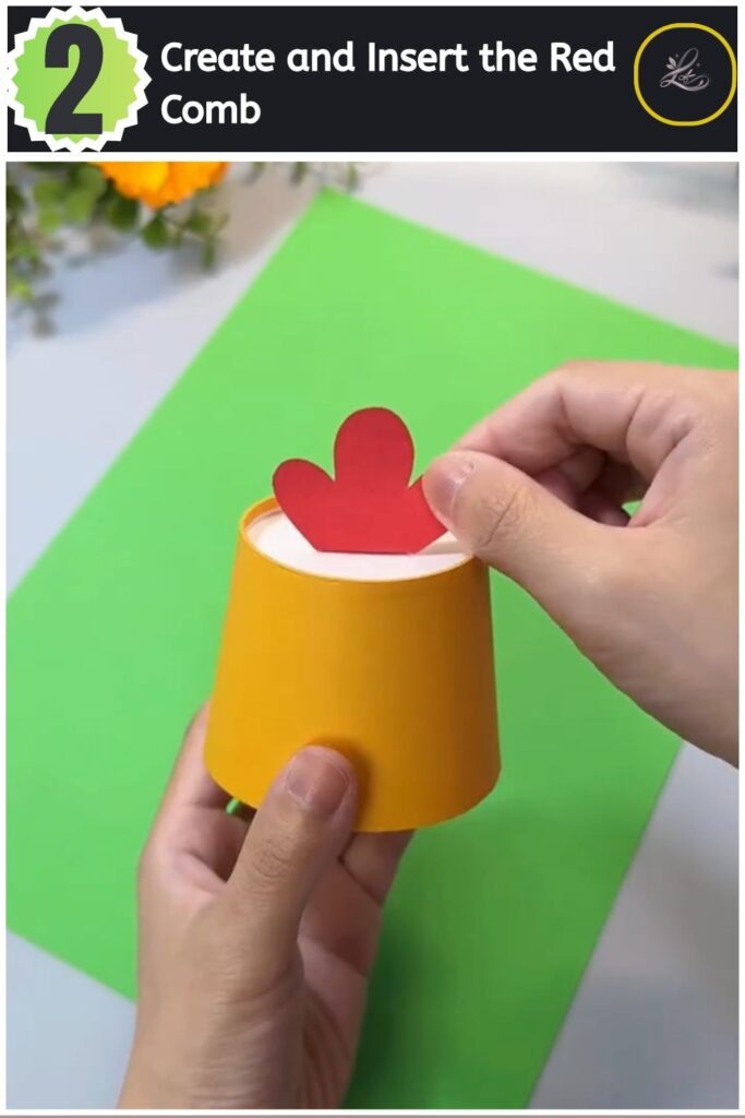 Adorable Paper Cup Chicken Craft for Beginners (#1) Sliding a red cardstock comb cutout into the top slit of an upside-down yellow paper cup.
