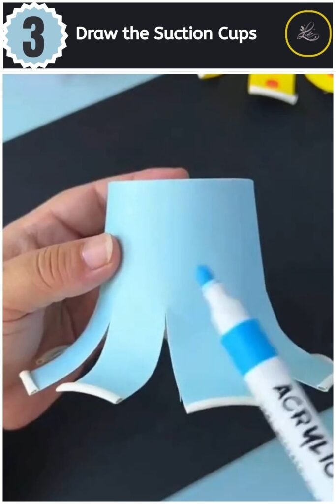 Playful Paper Cup Octopus Craft for Beginners Drawing blue spots onto the tentacles of a light blue paper cup octopus.