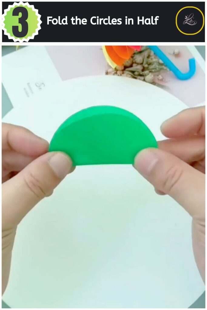 Folding a green paper circle in half to create a semi-circle