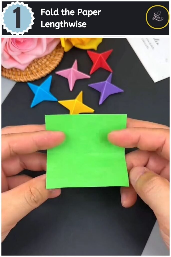 A rectangular strip of green paper being creased horizontally in half on a black surface.