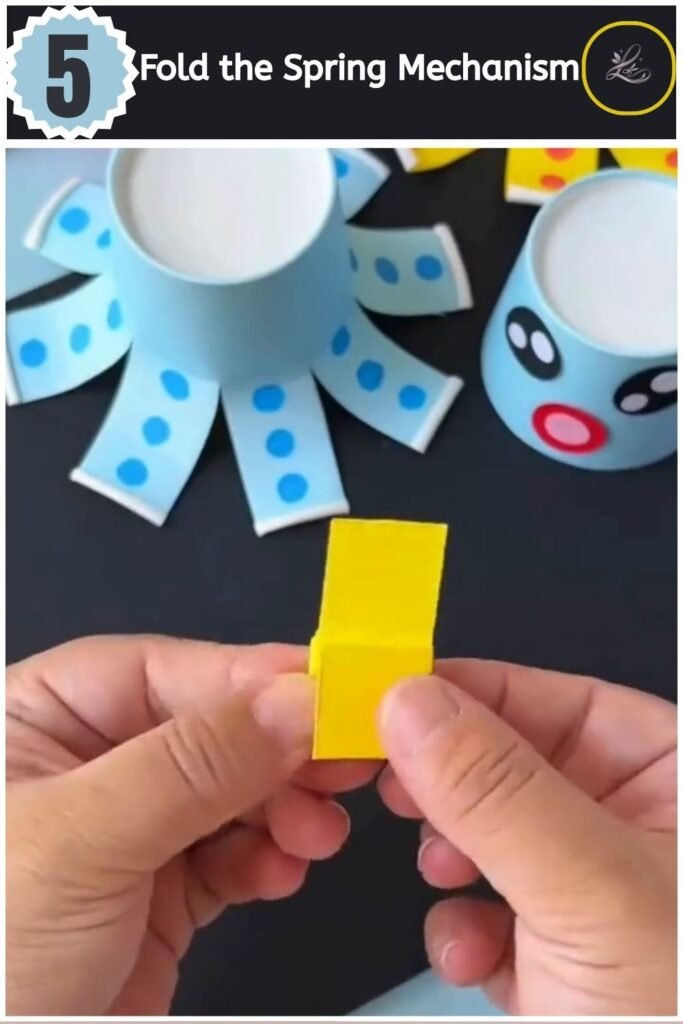Playful Paper Cup Octopus Craft for Beginners Accordion folding yellow paper strips to create a spring for an octopus toy.