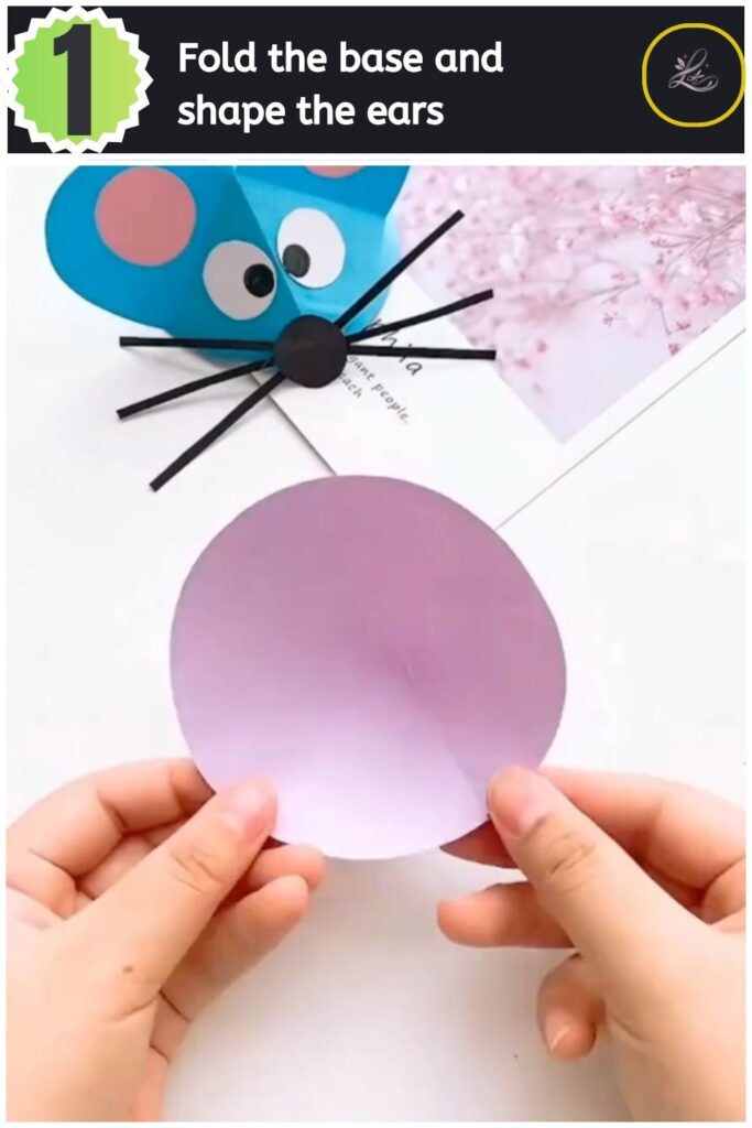 Adorable Paper Mouse Craft For Beginners Hands folding a purple paper circle to create the body and ears of a paper mouse.