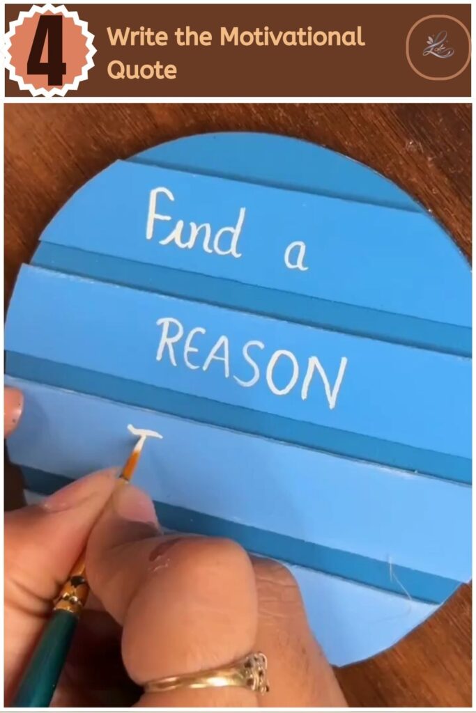Cute DIY Inspirational Wall Hanging Anyone Can Make Writing a motivational quote with white paint and a detail brush on a blue background.