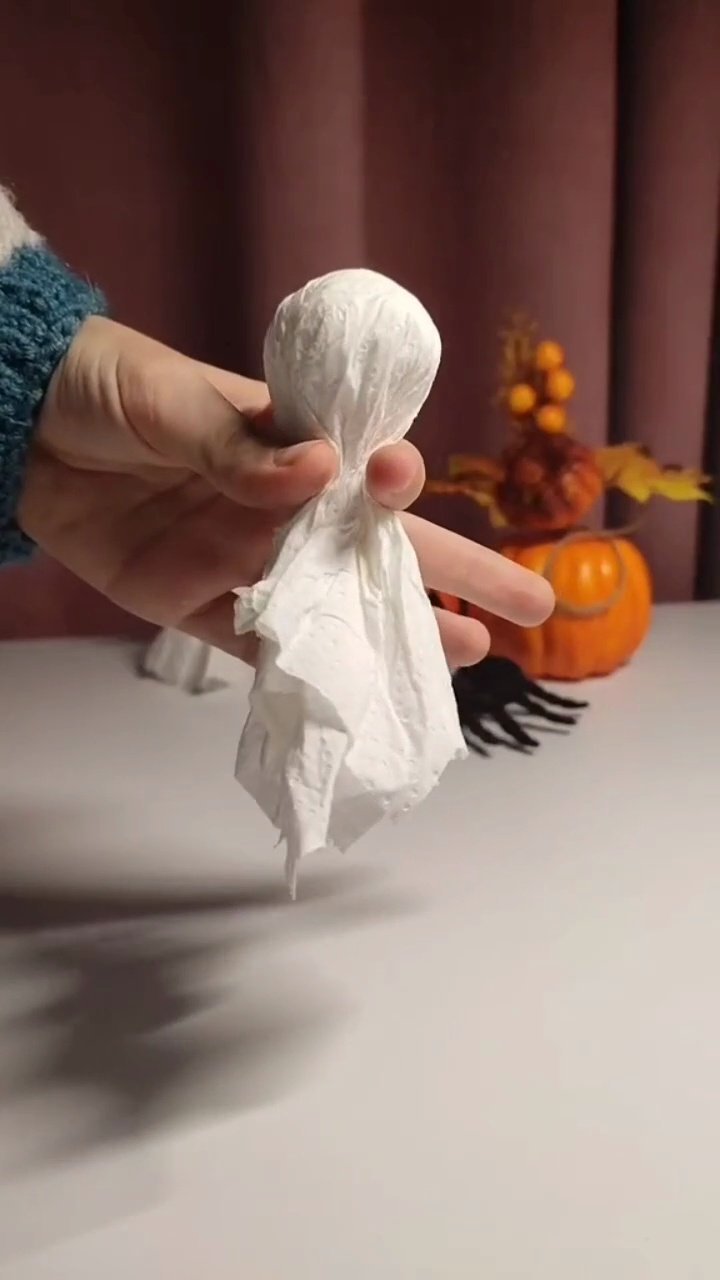 Easy DIY Paper Towel Ghosts (5-Minute Halloween Craft) Wrapping black rubber band around paper ghost neck