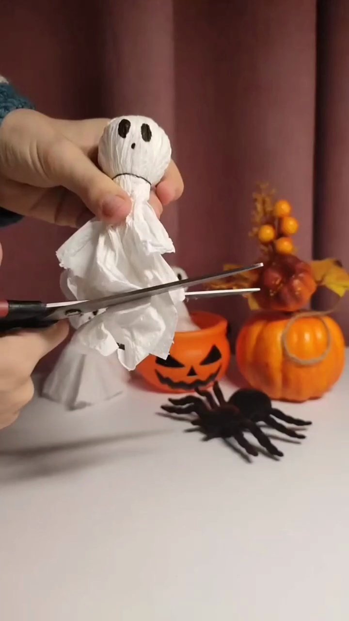 Easy DIY Paper Towel Ghosts (5-Minute Halloween Craft) Trimming bottom of paper ghost skirt with scissors