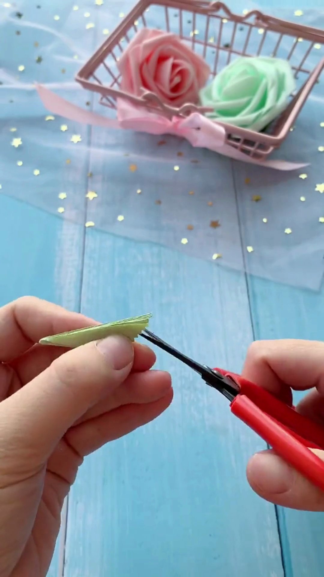Trimming edges of green paper with zig-zag pinking shears