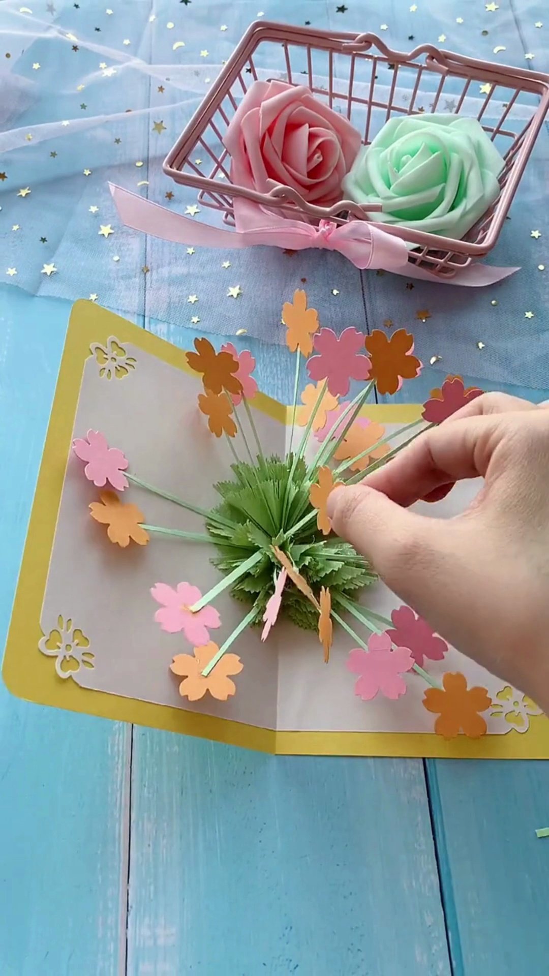 Inserting flower stems into green accordion pleats for 3D explosion